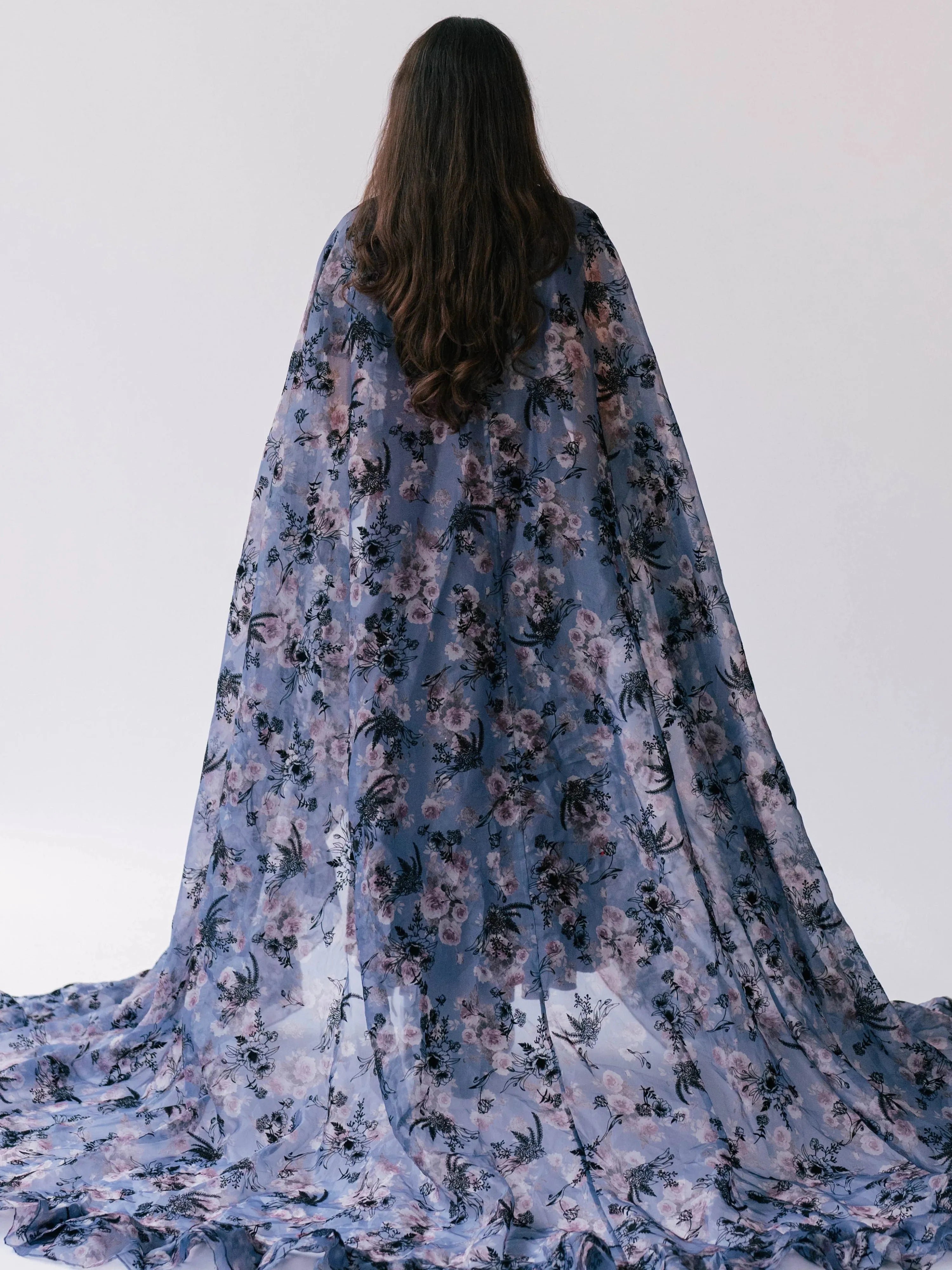 The High Priestess Victorian Cloak in sheer purple floral organza with ruffle trim, shown from the back with full train spread across the floor.