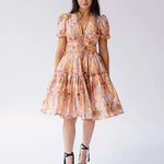 Ode To Jove Grace Day Dress featuring puff sleeves, V-neckline, and tiered mini skirt in soft fresco print. Ideal for spring and summer occasions.