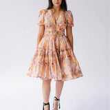 Ode To Jove Grace Day Dress featuring puff sleeves, V-neckline, and tiered mini skirt in soft fresco print. Ideal for spring and summer occasions.