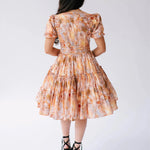 Back view of Ode To Jove Grace Day Dress showing tiered skirt and fitted waist in soft fresco print. Elegant and flattering from every angle.