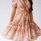 Close-up of Ode To Jove Grace Day Dress showing detailed fresco print, ruched bodice, and swishable tiered skirt. Feminine and structured design.