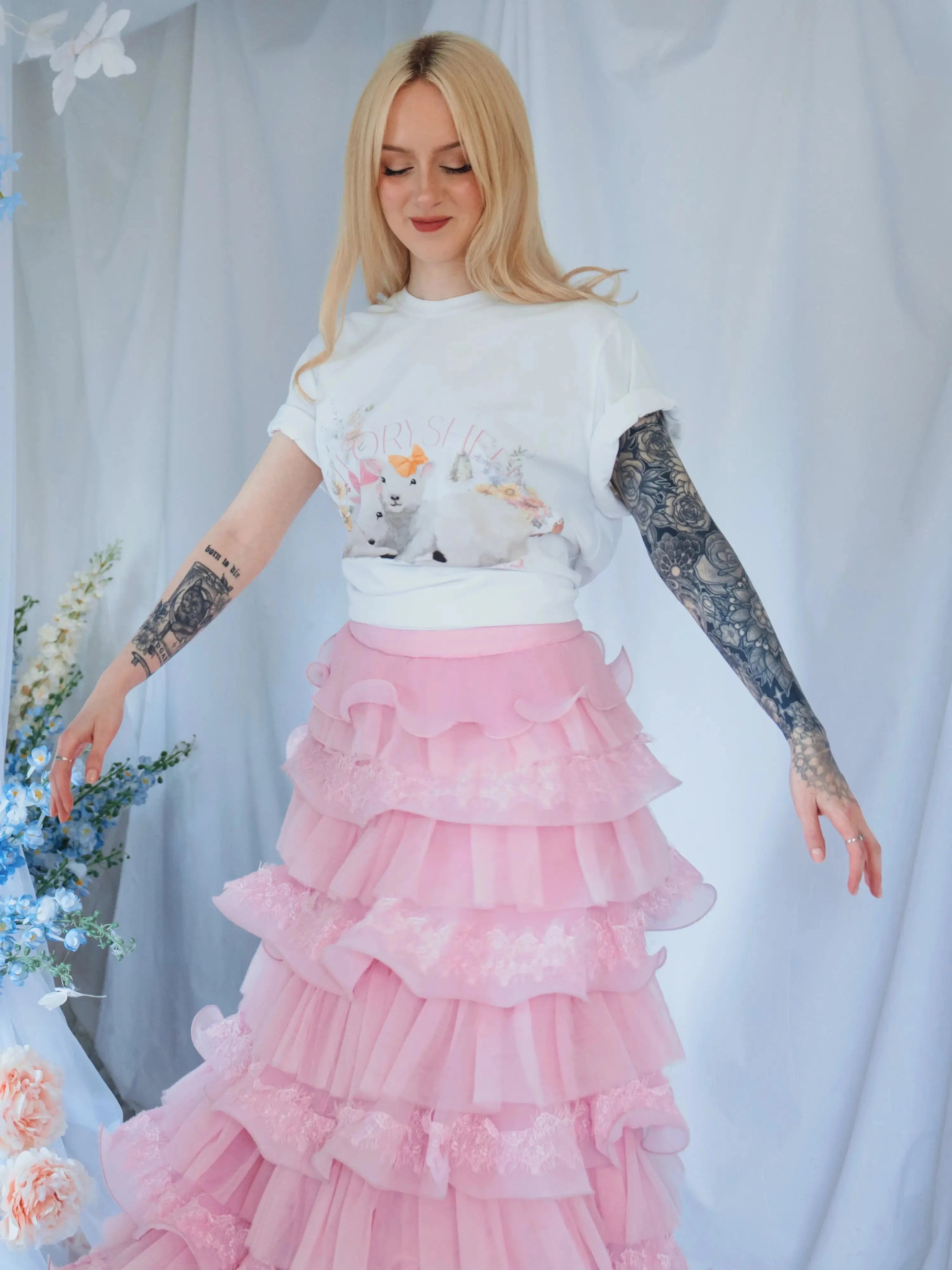 The Little Lamb Tee styled with a pink ruffled skirt, ideal for lovers of soft, romantic cottagecore fashion and whimsical prints.