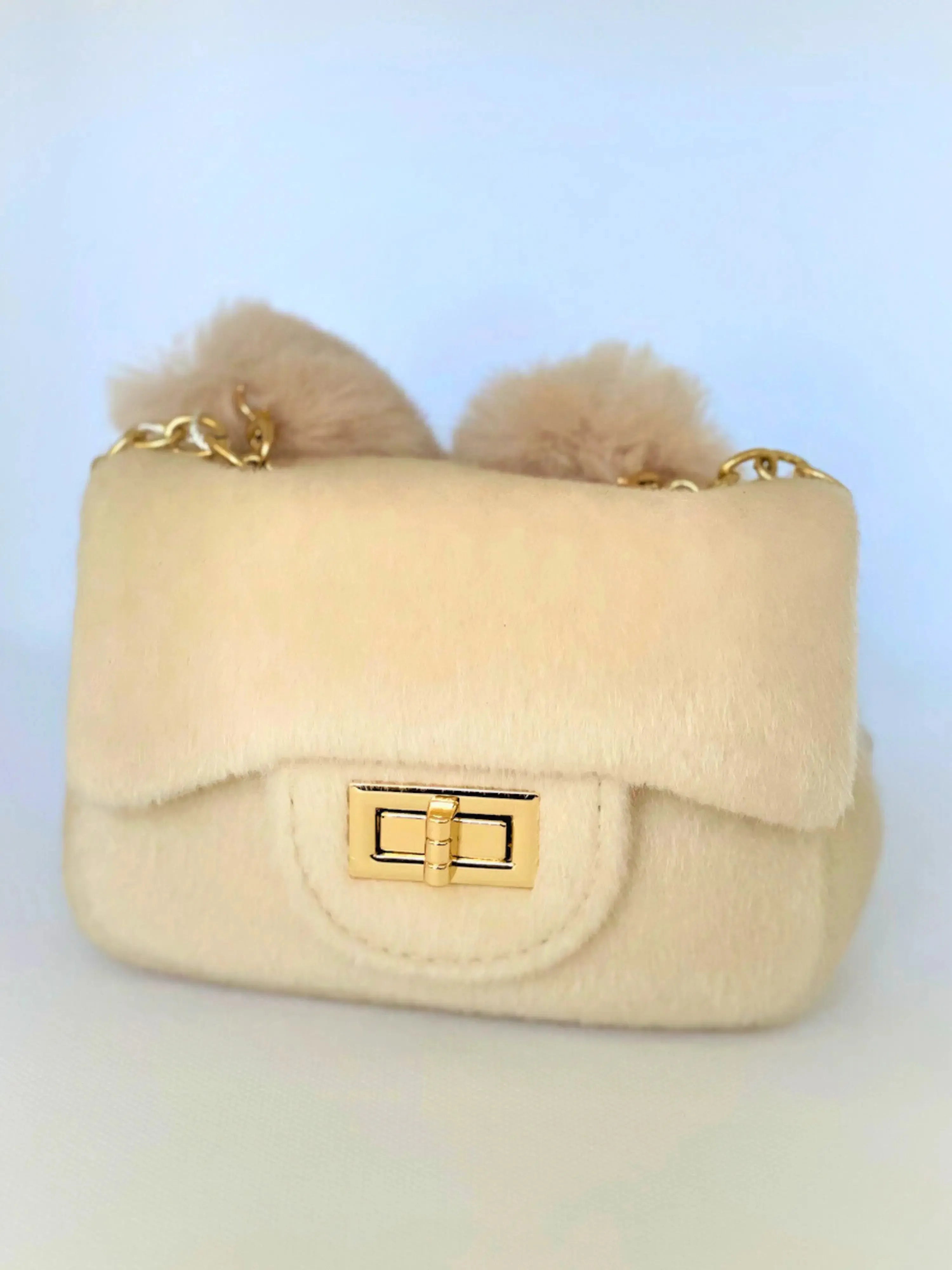 Ivory The Petit Agneau Tiny Purse with gold chain strap and faux fur texture, combining elegance and compact design in a micro handbag.