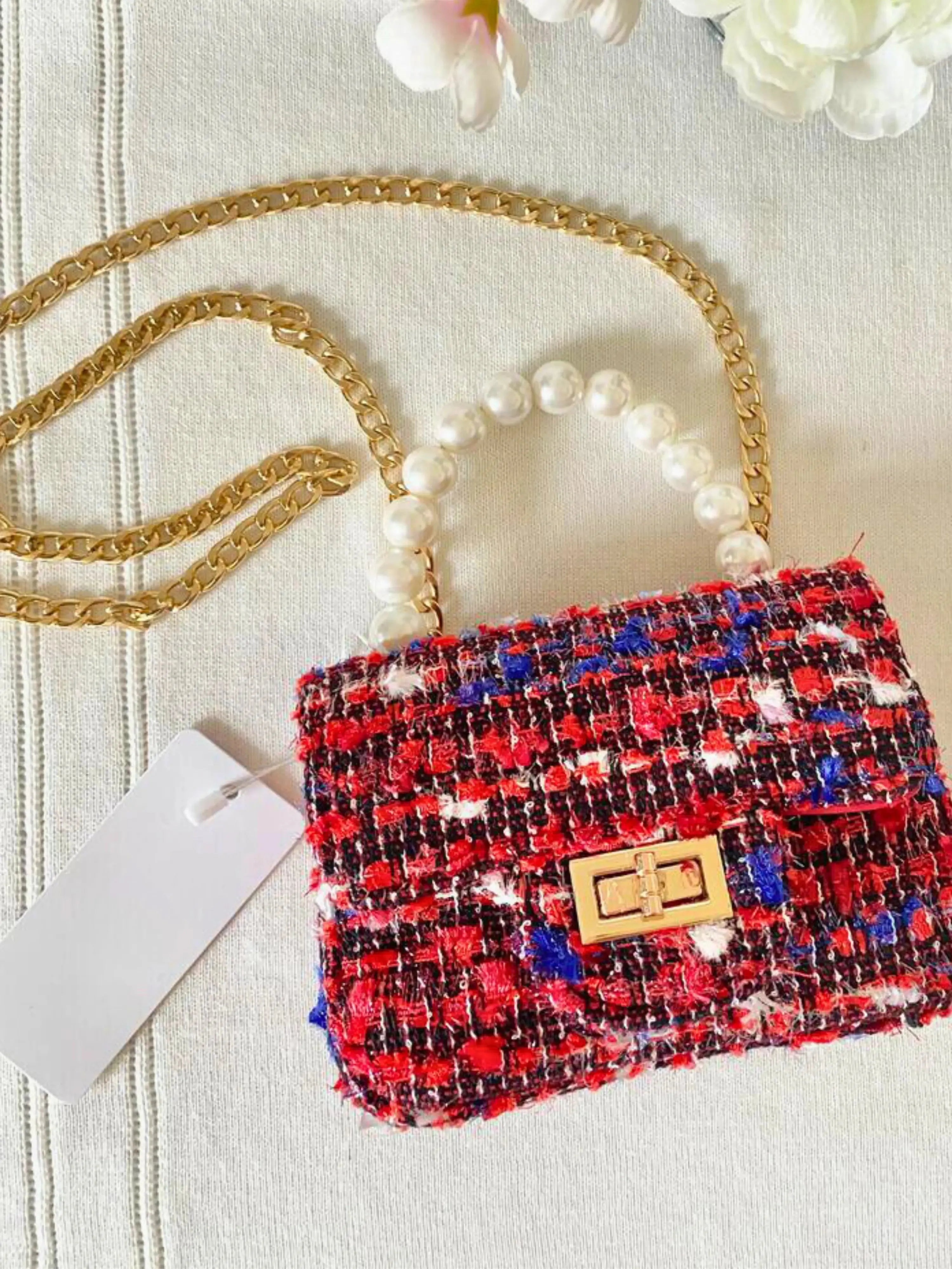 Front view of The Little Lady Tweed Mini Purse featuring textured tweed fabric, pearl top handle, and detachable gold chain for elegant wear.
