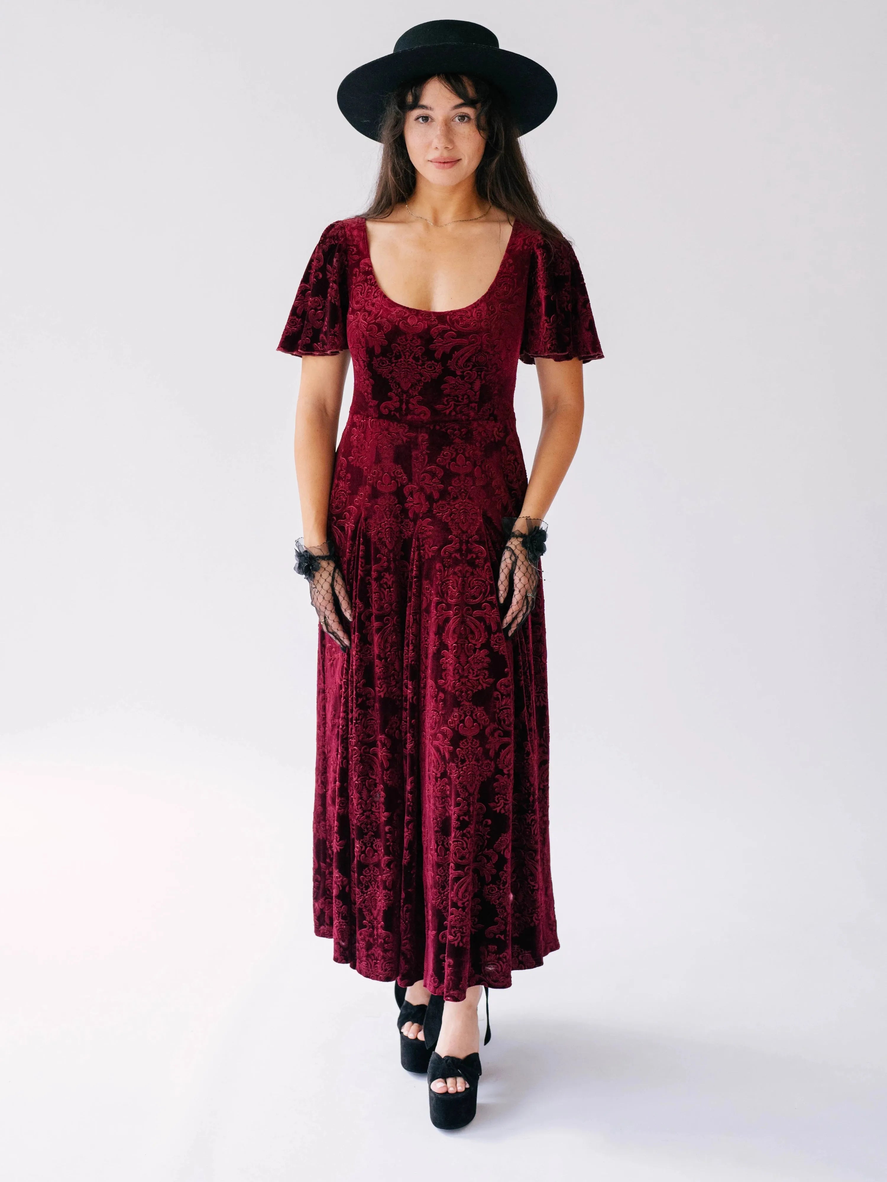 The Scarlet Red Velvet Viola Dress with butterfly sleeves and Victorian pattern, styled with black hat and gloves.