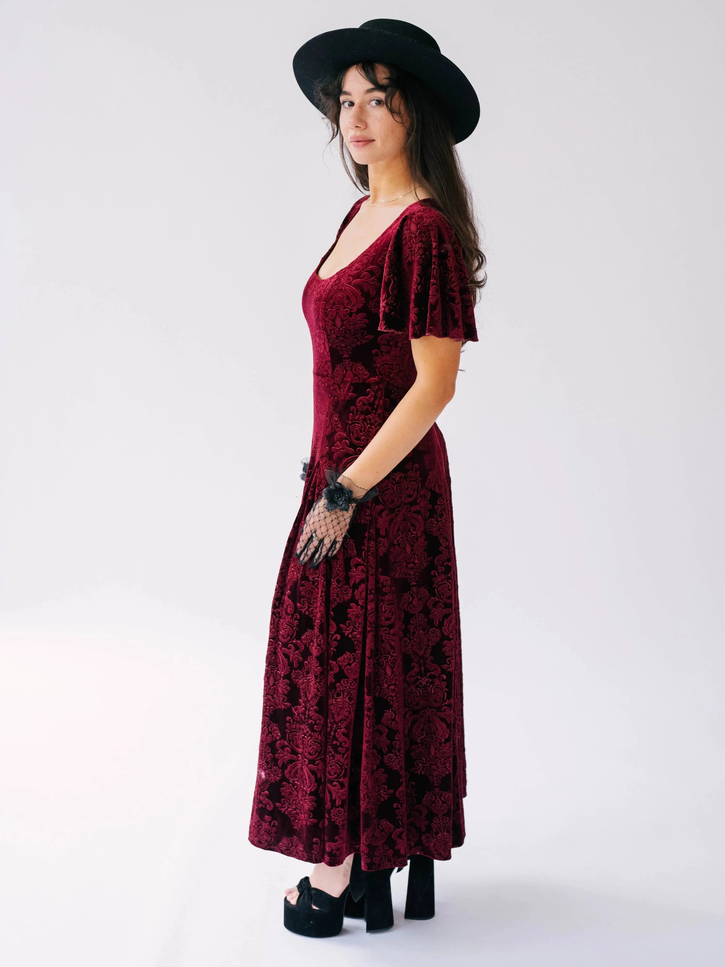 Side profile view of The Scarlet Red Velvet Viola Dress featuring butterfly sleeves and baroque velvet detailing.