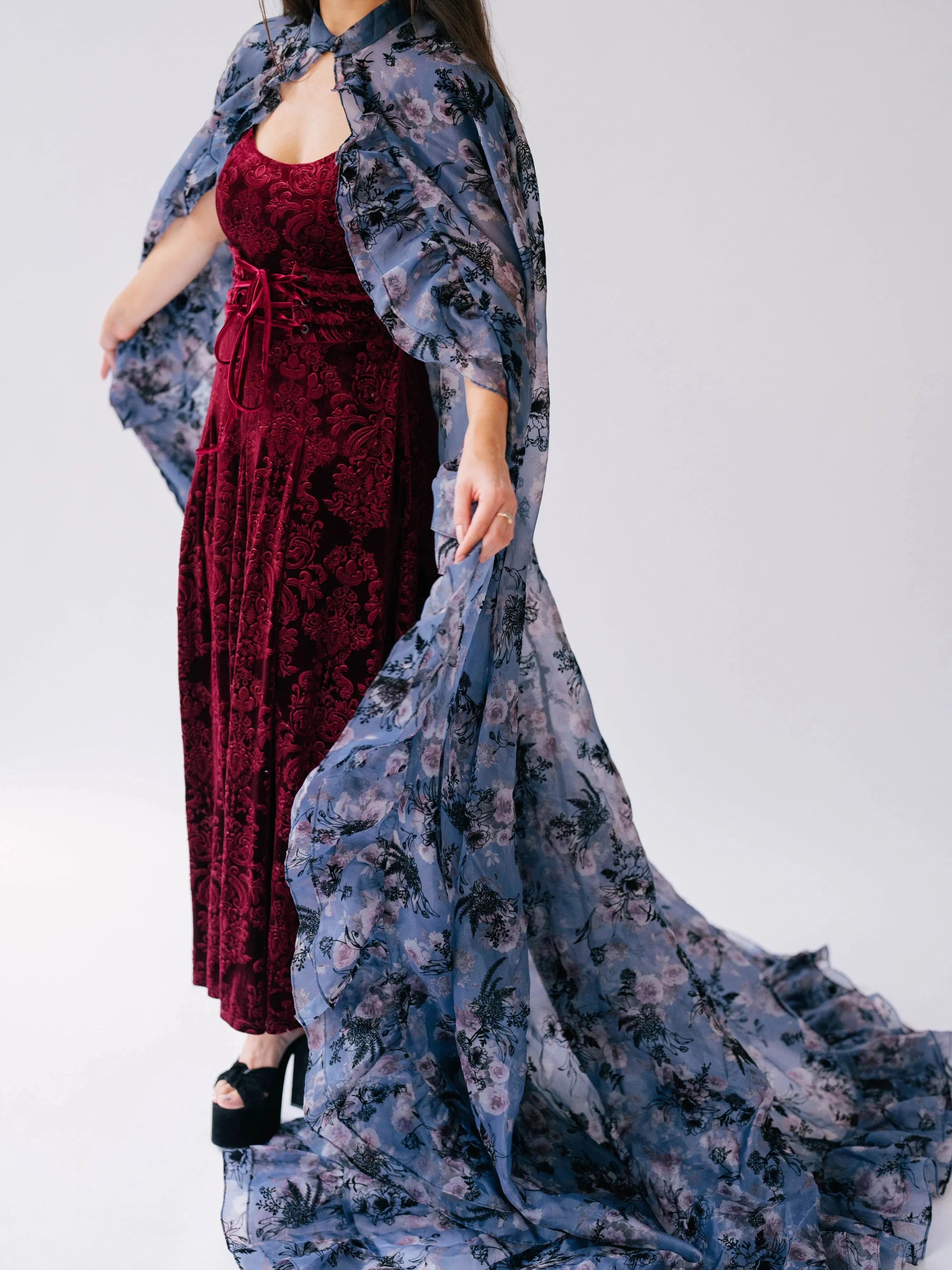 The Scarlet Red Velvet Viola Dress styled with a flowing floral cape.