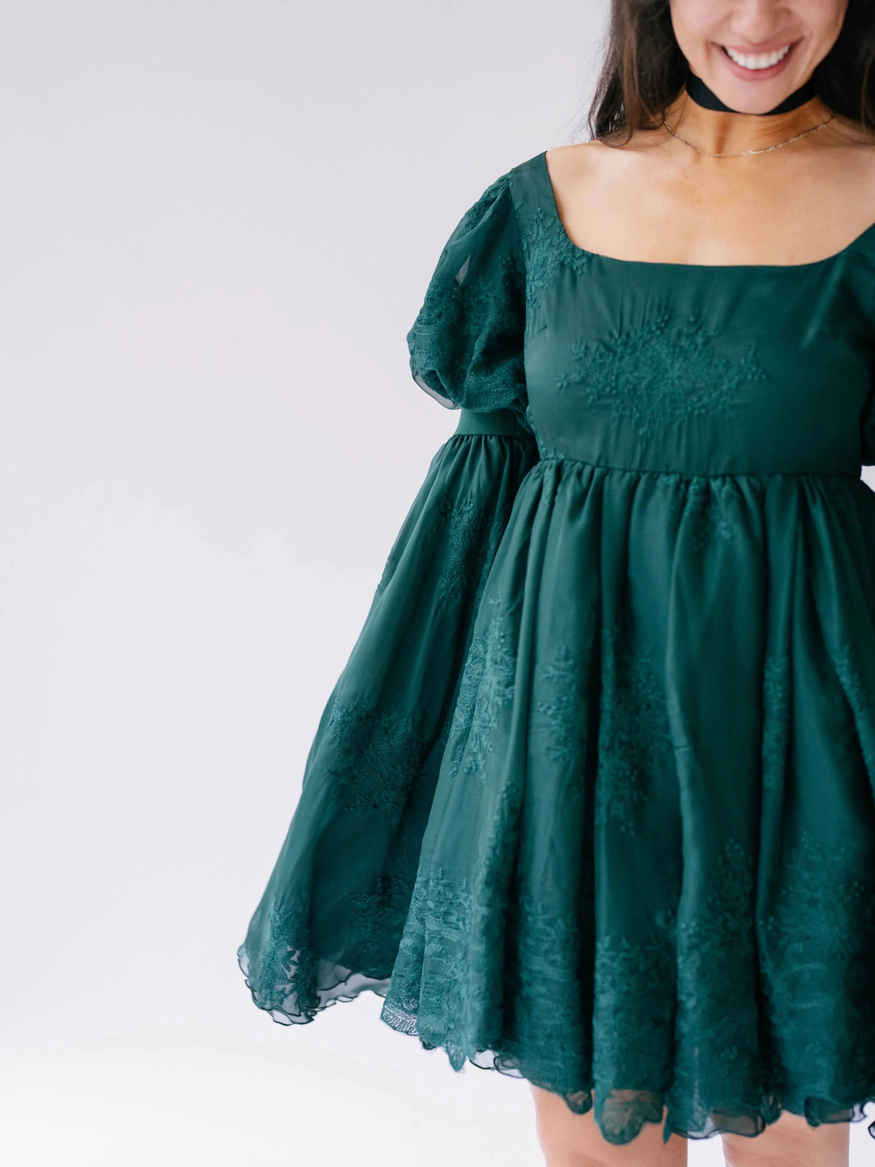 Close-up view of the woodland bell sleeve dress showcasing the embroidered details.