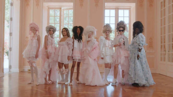 Group of women in pink and white selkie inspired outfits with grand bow sashes at Let Them Eat Cake Party.