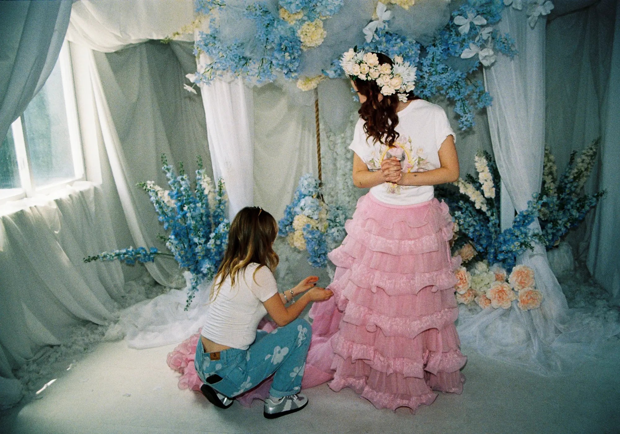 Two women in a dreamy floral setting showcasing slow fashion women's clothing.