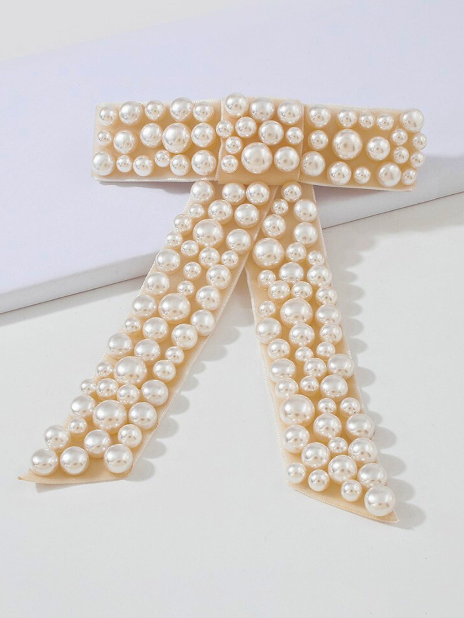 The Pearl Bow Barrette - Who doesn't love a hair bow!? The Pearl Bow Barrette is the cutest accessory to add to your wardrobe, adorned is pearl embellishments and made of an ivory velvet fabric. This barrette features a high quality clip that can hold the