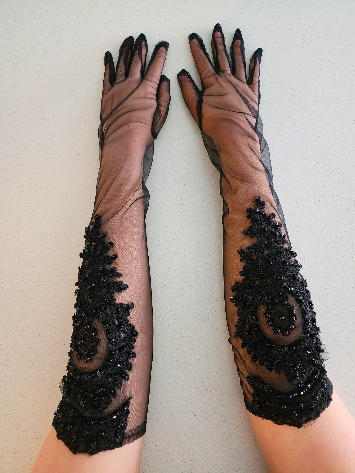 The Adorned Lace Gloves - The Adorned Lace Glove is a true testament to the artistry of detail. Meticulously crafted from luxurious tulle and adorned with delicately hand-sewn lace appliques, this glove is a testament to sophistication and elegance for th