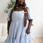 Light blue taffeta corset midi dress with puff sleeves and a tiered ruffle skirt.