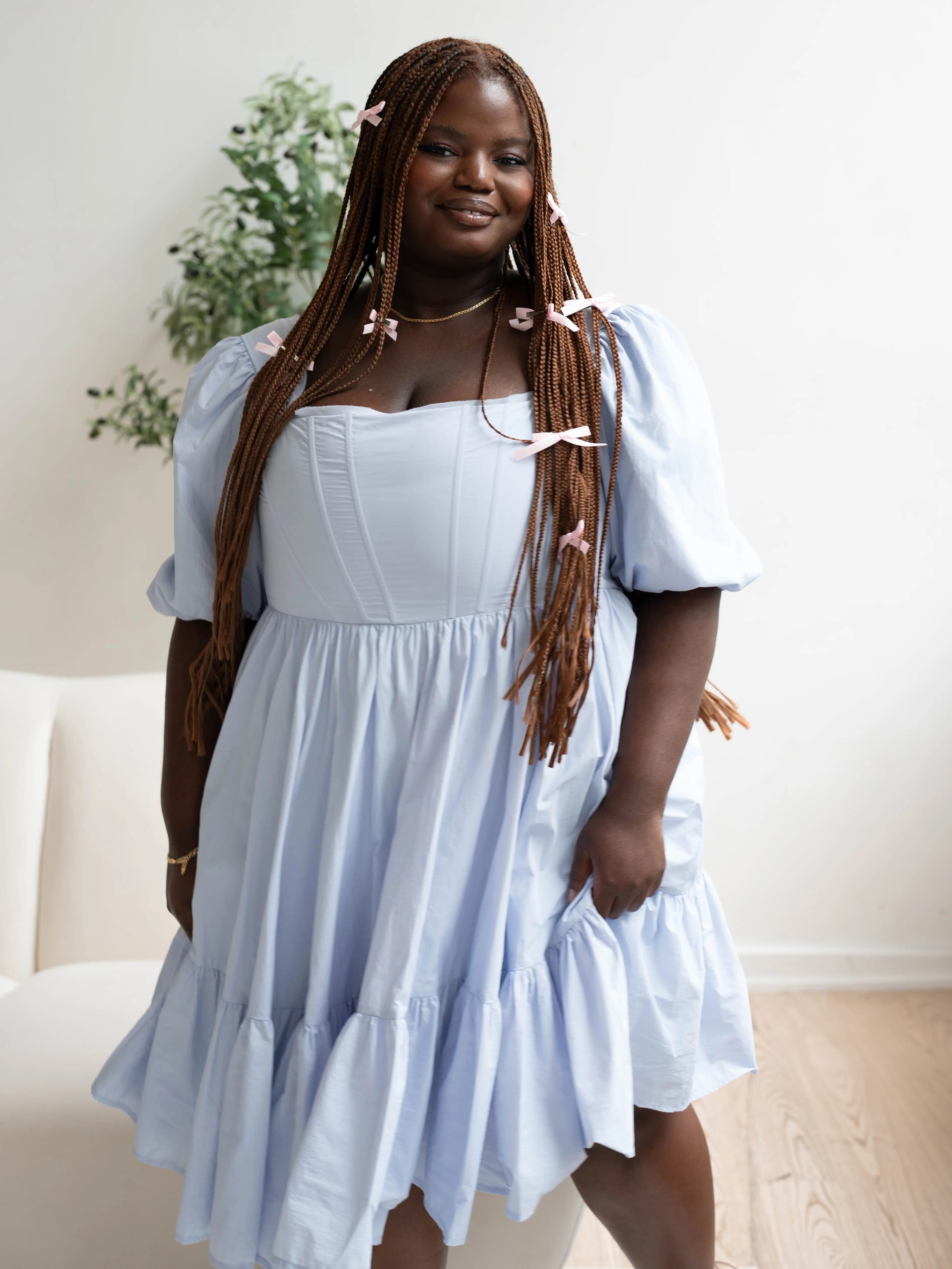 Light blue taffeta corset midi dress with puff sleeves and a tiered ruffle skirt.