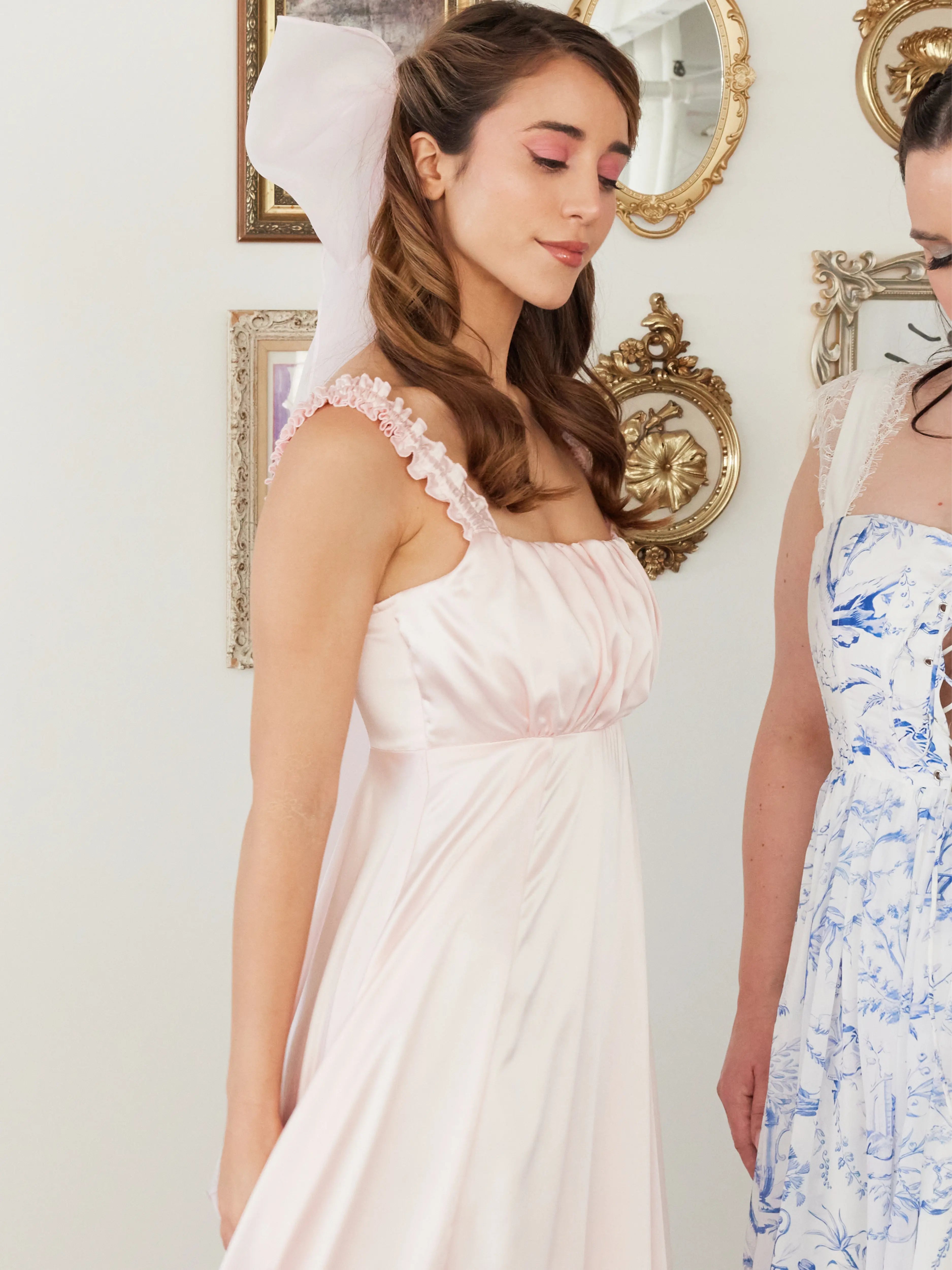 Ruffled sleeve pink satin dress with empire waist paired with a grand pink hair bow.