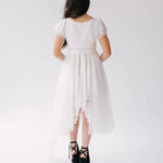 Back view of Belladonna Lace Dress showing lace bodice, flutter sleeves, and long tulle train cascading from high-low hem.
