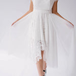 Front detail of Belladonna Lace Dress with sheer tulle overlay and scalloped lace hem, styled for modern bridal wear.