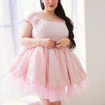 A pink tulle mini dress with cap sleeves and a square neckline.