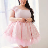 A pink tulle mini dress with cap sleeves and a square neckline.