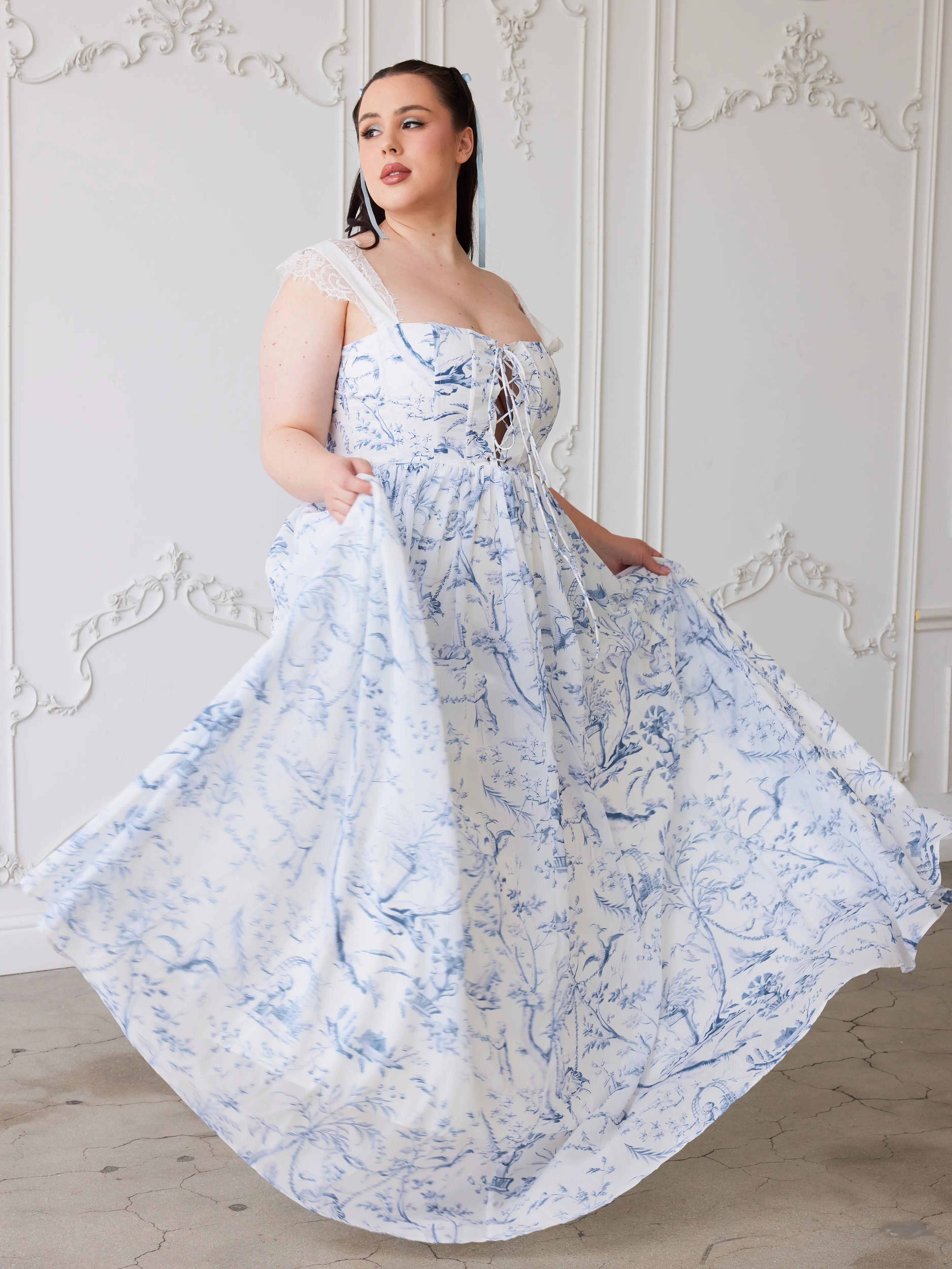 A flowing corset gown in white polyester chiffon fabric with delicate blue floral toile patterns.