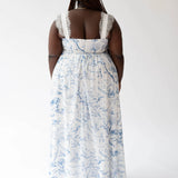 White and blue floral print maxi dress with lace straps viewed from behind.