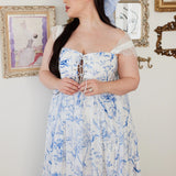 Lace strap, white maxi dress with delicate blue toile print and lace-up corset bodice, paired with an extra large hair bow adorned with the same blue toile print.