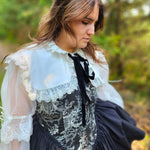 Woman in Victorian inspired corset mini dress featuring lace trim. showcasing the Ciela Snow White Shrug