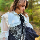 Woman in Victorian inspired corset mini dress featuring lace trim. showcasing the Ciela Snow White Shrug