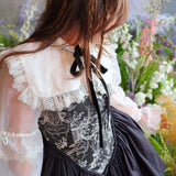 Woman wearing The Ciela Shrug Top featuring lace trim collar and black ribbon tie, overtop a corset mini dress