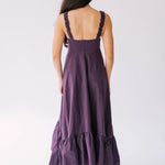 Long purple dress with ruffled hem and ruched shoulder straps.