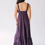 Long purple dress with ruffled hem and ruched shoulder straps.