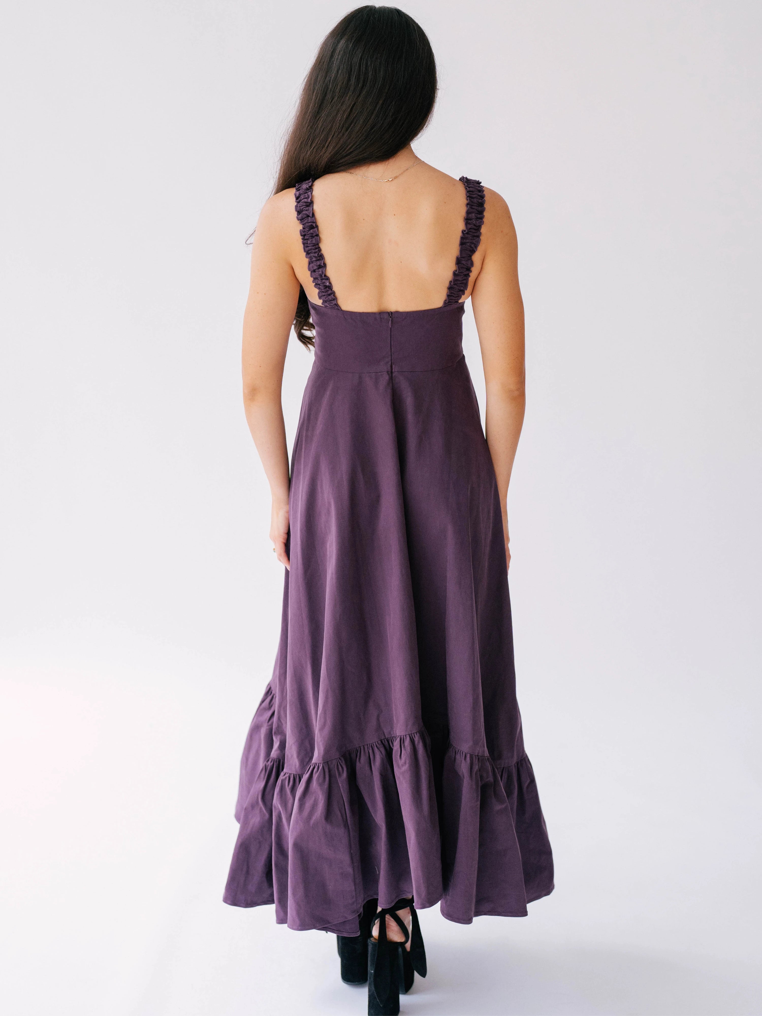 Long purple dress with ruffled hem and ruched shoulder straps.