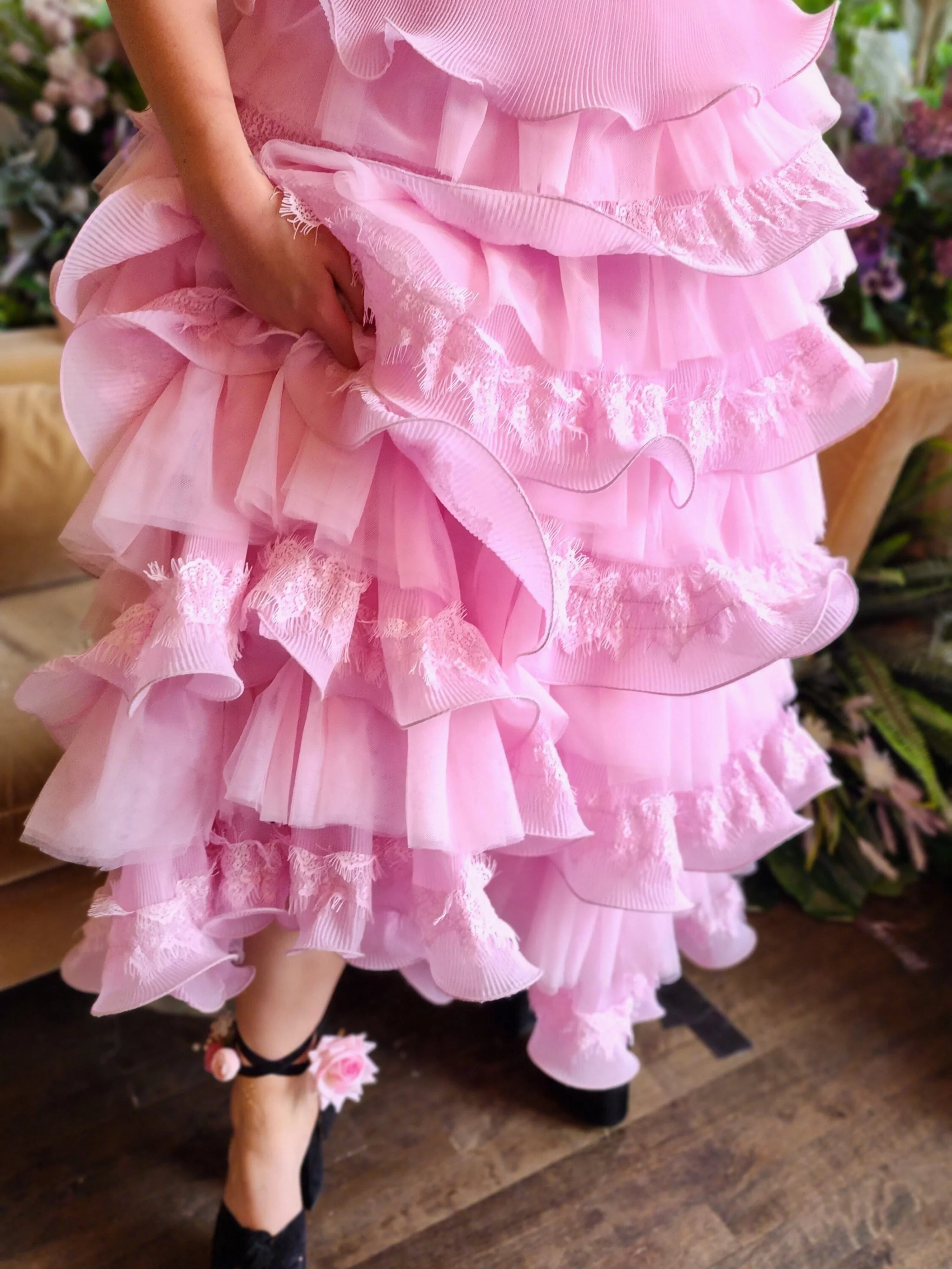 Frilly pink Dahlia Ruffle Skirt with tiers and snap closure buttons, close up photo.