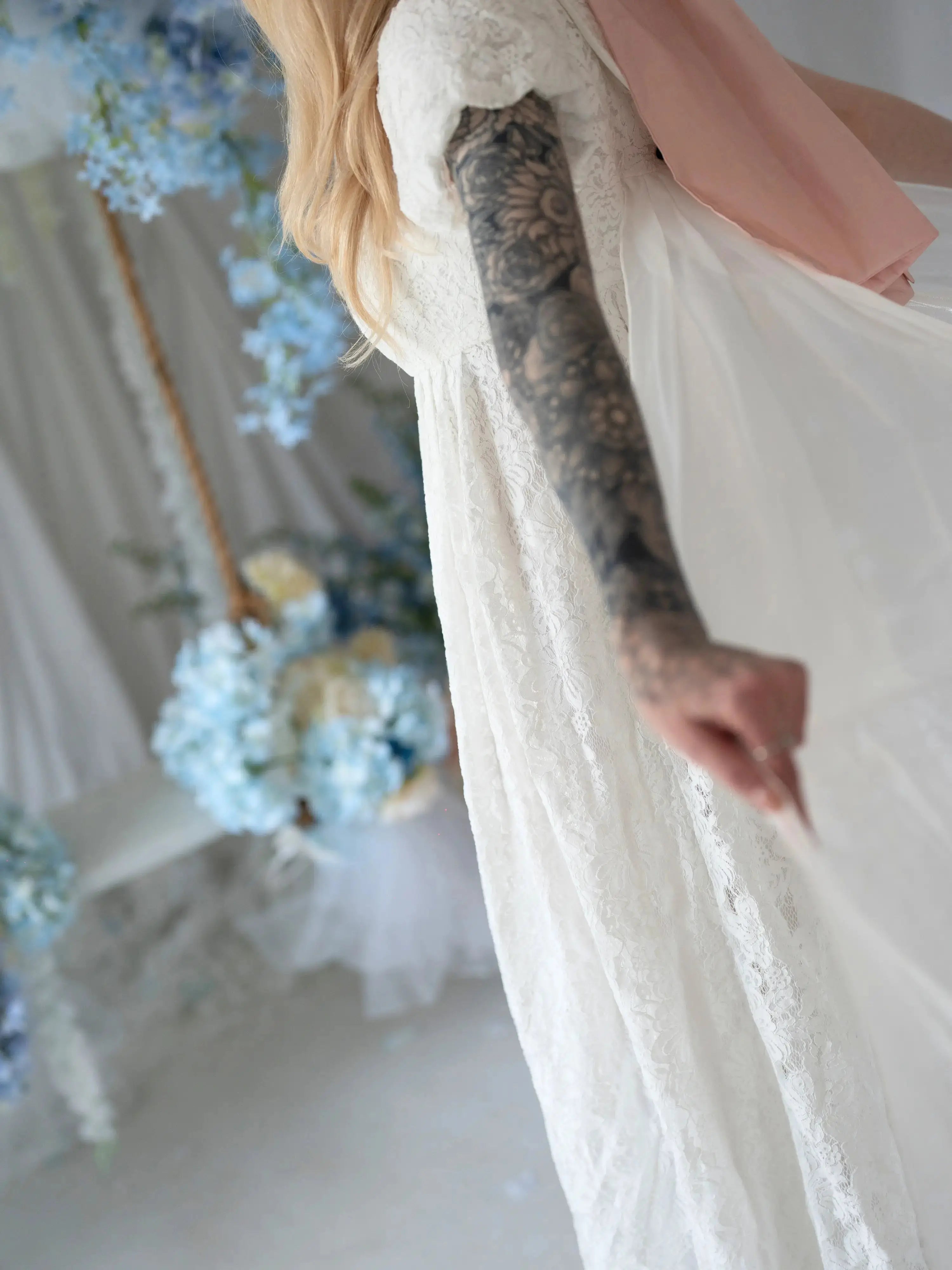 Close-up of Dauphine Lace Gown's lace texture and flowing fabric, highlighting the gown's dreamy and ethereal bridal design.