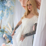Romantic Dauphine Lace Gown with empire waist and soft lace, styled with oversized pink bow in a dreamy bridal setting.