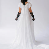 Back view of Dauphine Lace Gown with long train and empire waist, styled with black accessories for a unique wedding dress look.
