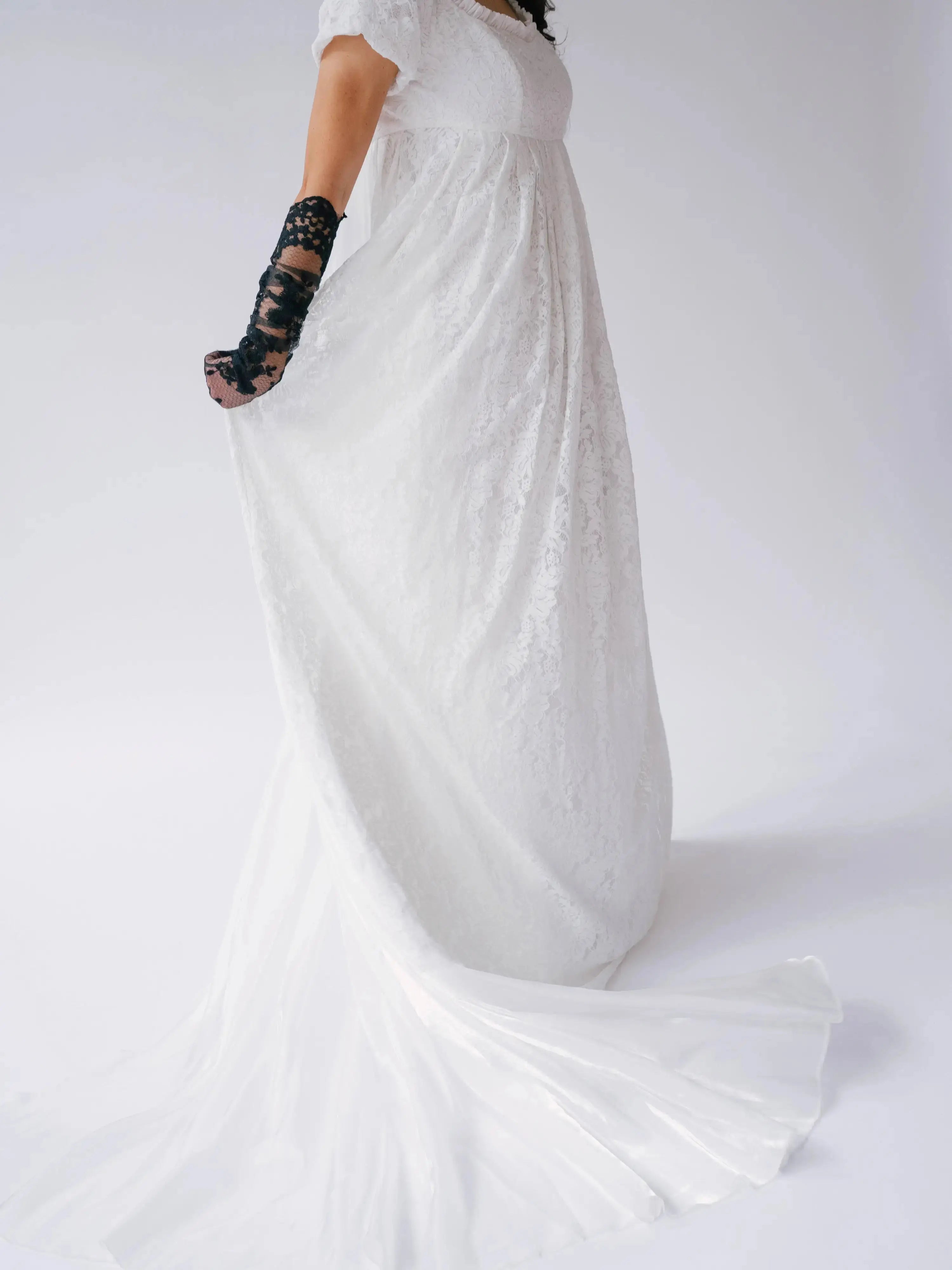 Flowing train of Dauphine Lace Gown in motion, emphasizing the gown's ethereal lace and lightweight bridal design.