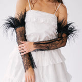 White ruffled mini dress with black lace and feather sleeves.