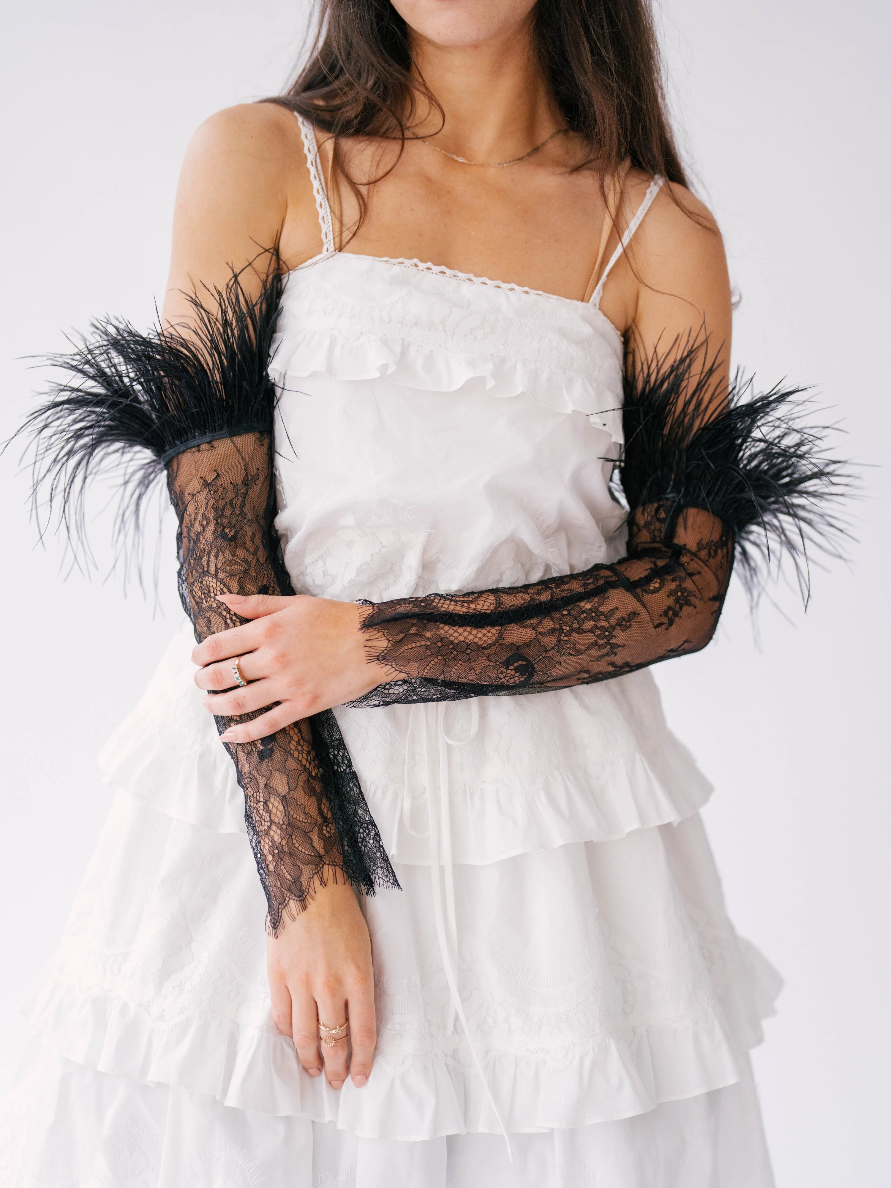 White ruffled mini dress with black lace and feather sleeves.