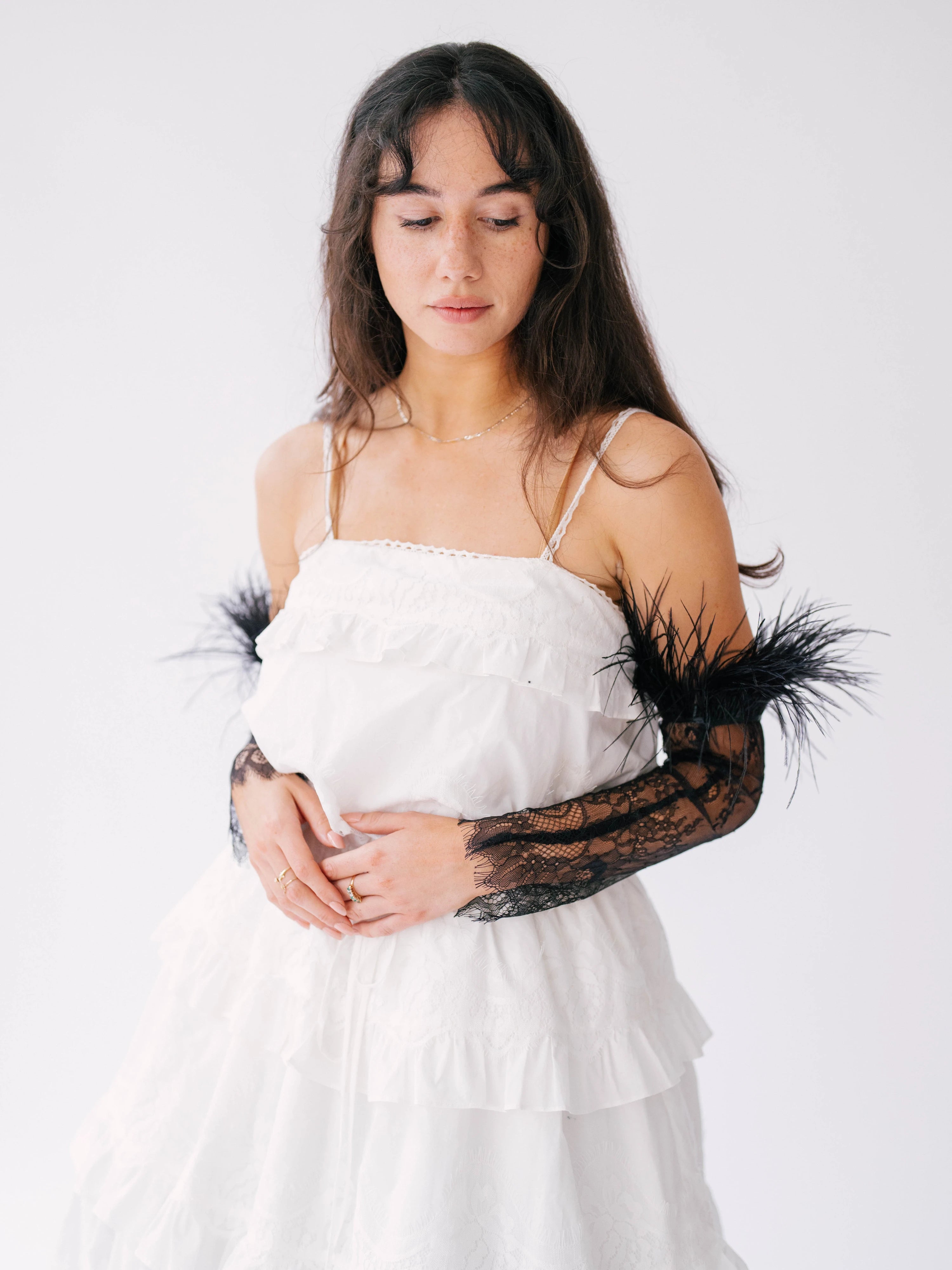 White layered party dress with black feathered lace sleeve gloves.