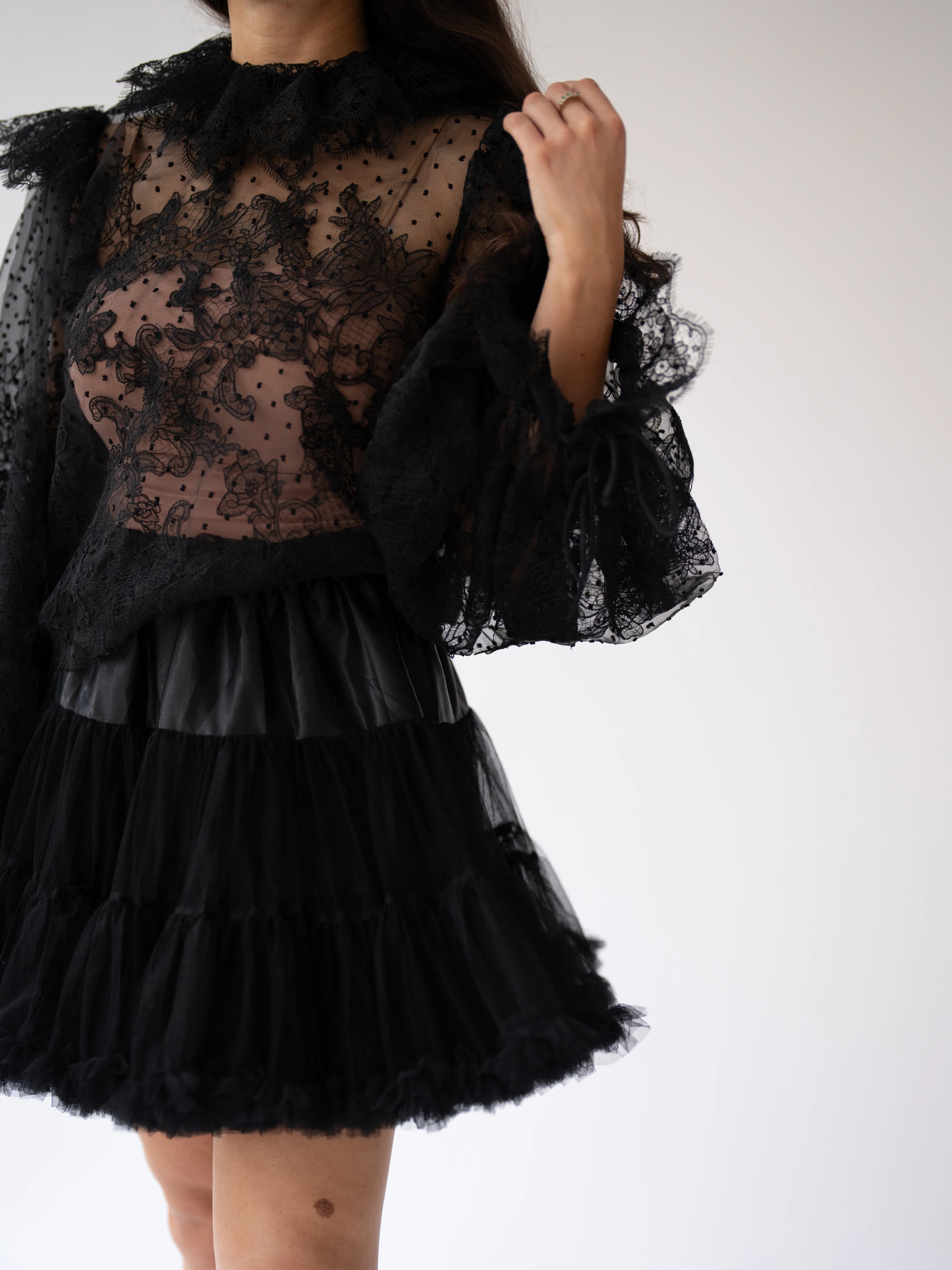 Black lace blouse with sheer bodice and a floral lace design.