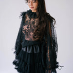 A gothic-style black lace top with sheer puff sleeves.