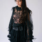 A gothic-style black lace top with sheer puff sleeves.