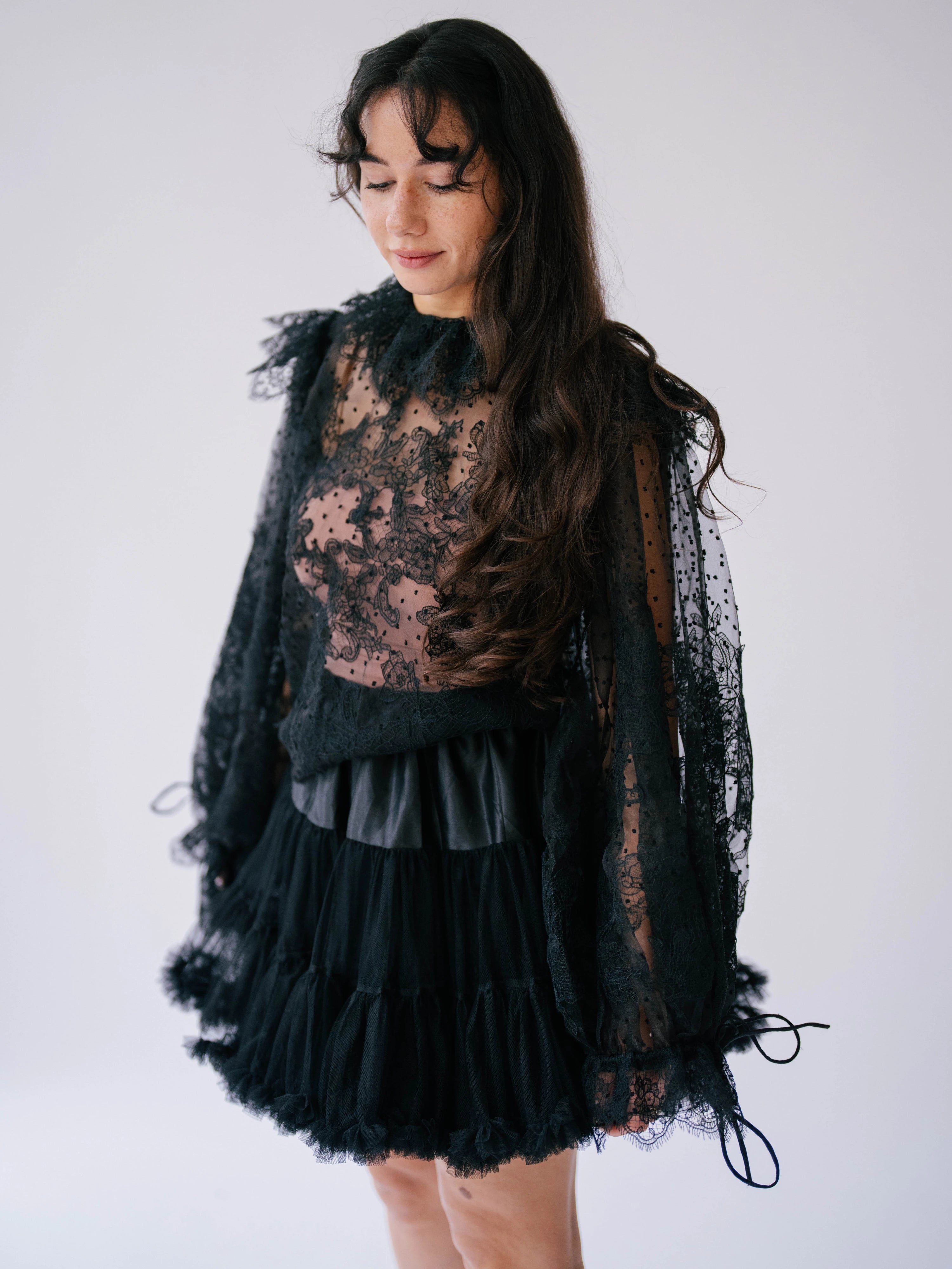 A gothic-style black lace top with sheer puff sleeves.