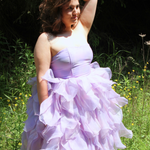 Lavender ruffled Eventyr Tulip Dress with fitted bodice and voluminous hand-dyed skirt worn by a woman in a field to create a fairytale experience.