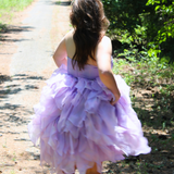 Lavender tulle Eventyr Tulip Dress with ruffled layers worn by a woman on a path.