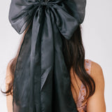 Black satin bow hair accessory with ribbons, perfect addition for a gown or puff dress.