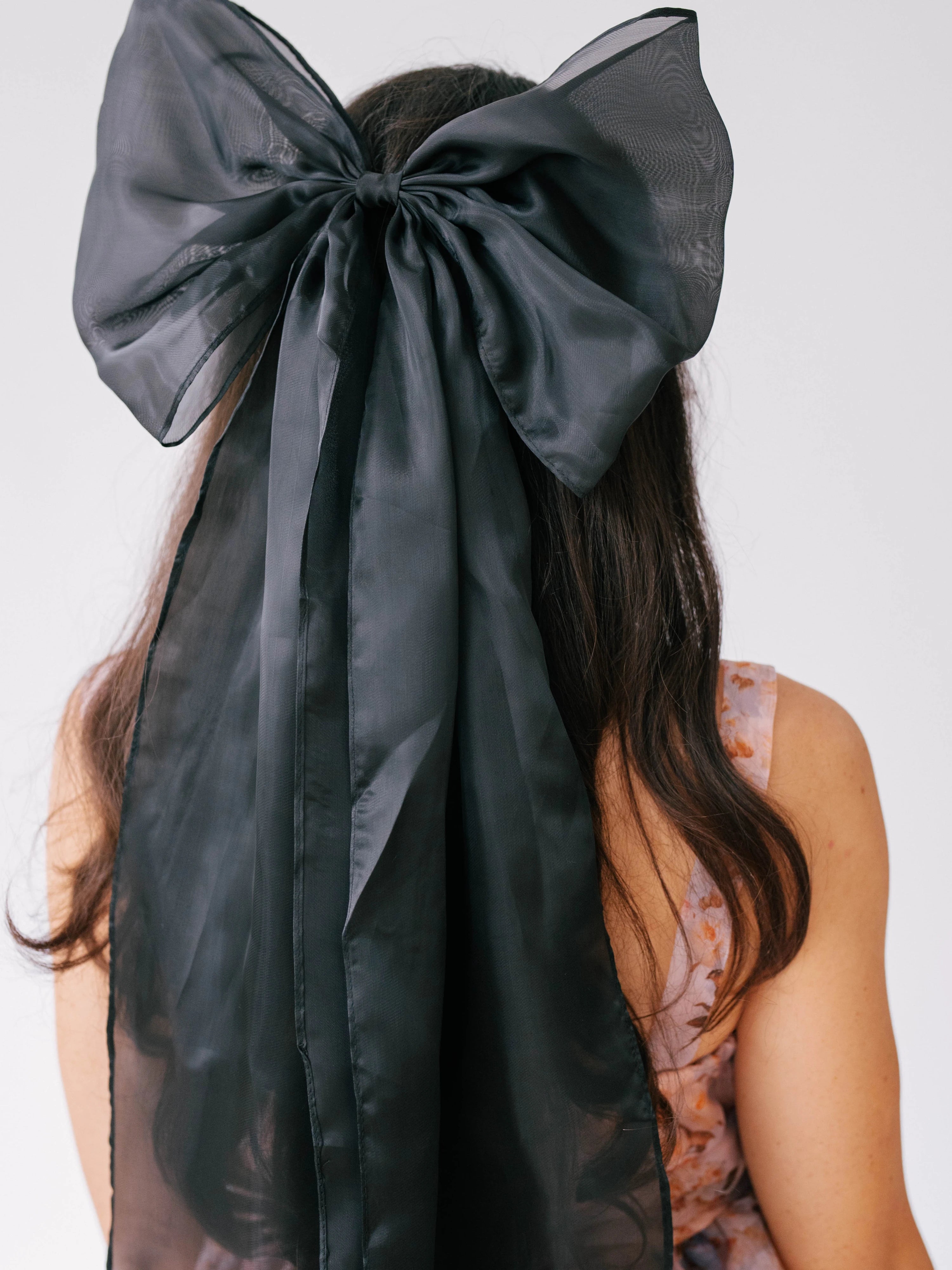 Black satin bow hair accessory with ribbons, perfect addition for a gown or puff dress.