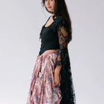A black lace top with dramatic black lace billowing sleeves. Overtop a bustle maxi skirt.