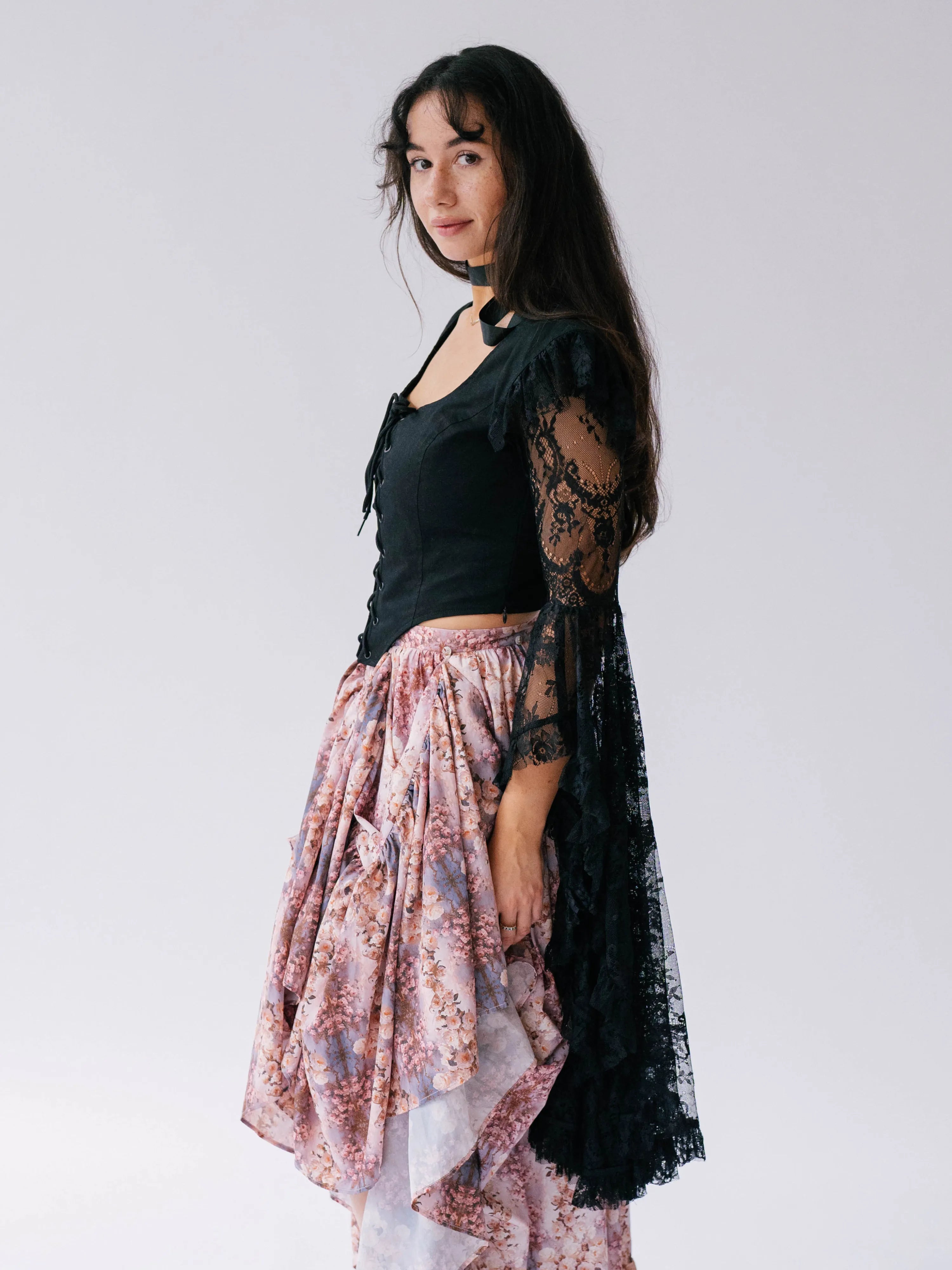 A black lace top with dramatic black lace billowing sleeves. Overtop a bustle maxi skirt.